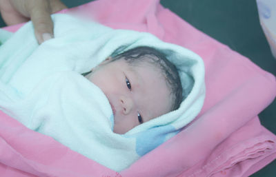 Close-up of cute baby girl wrapped in blanket