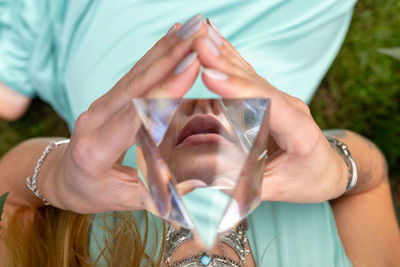 Midsection of woman holding crystal pyramid