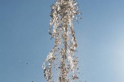 Close-up of water splashing against blue sky