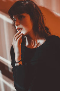 Close-up of woman against wall at home