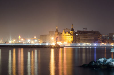 Illuminated haydarpasa terminal by sea against sky at night