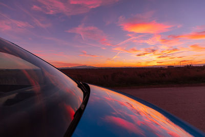Cropped image of car against sky during sunset