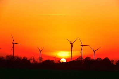 Scenic view of sunset and windmills