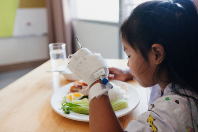 Side view of boy eating food at home