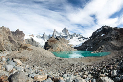 Scenic view of snowcapped mountains and lake against cloudy sky in los glaciares national park