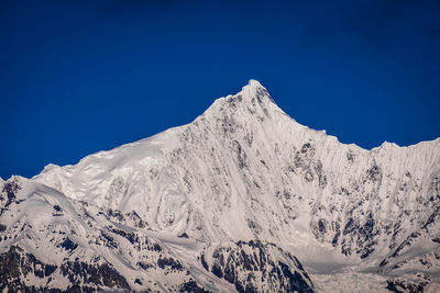 Scenic view of snowcapped mountains against clear blue sky