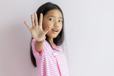 Portrait of a girl standing against white background