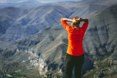 Rear view of woman standing against mountains