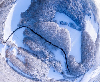 Aerial winter landscape. road leading through snowcapped winter forest. aerial view. 