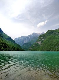 Scenic view of lake by mountains against sky