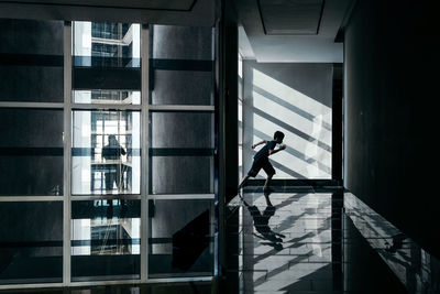 Side view of teenage boy running on floor