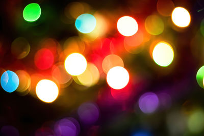 Defocused image of illuminated christmas lights at night