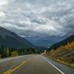 Empty road against cloudy sky