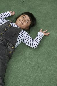 Portrait of girl lying on carpet at home