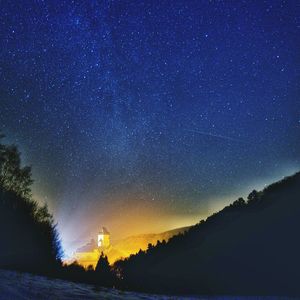 Scenic view of silhouette mountain against star field at night