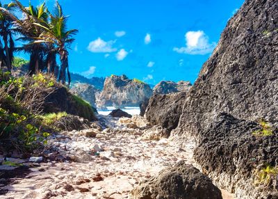 Scenic view of rocks by sea against sky