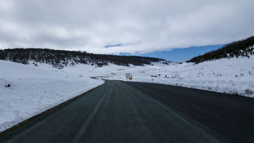 Empty road against cloudy sky in winter