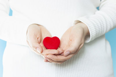 Red heart in female hands front view, a health care concept