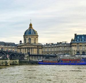 View of cathedral at waterfront against cloudy sky