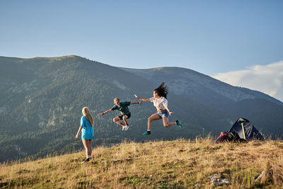 Group of people on landscape against mountain range