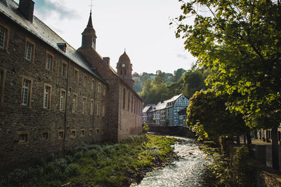 Panoramic view of river amidst buildings and trees against sky