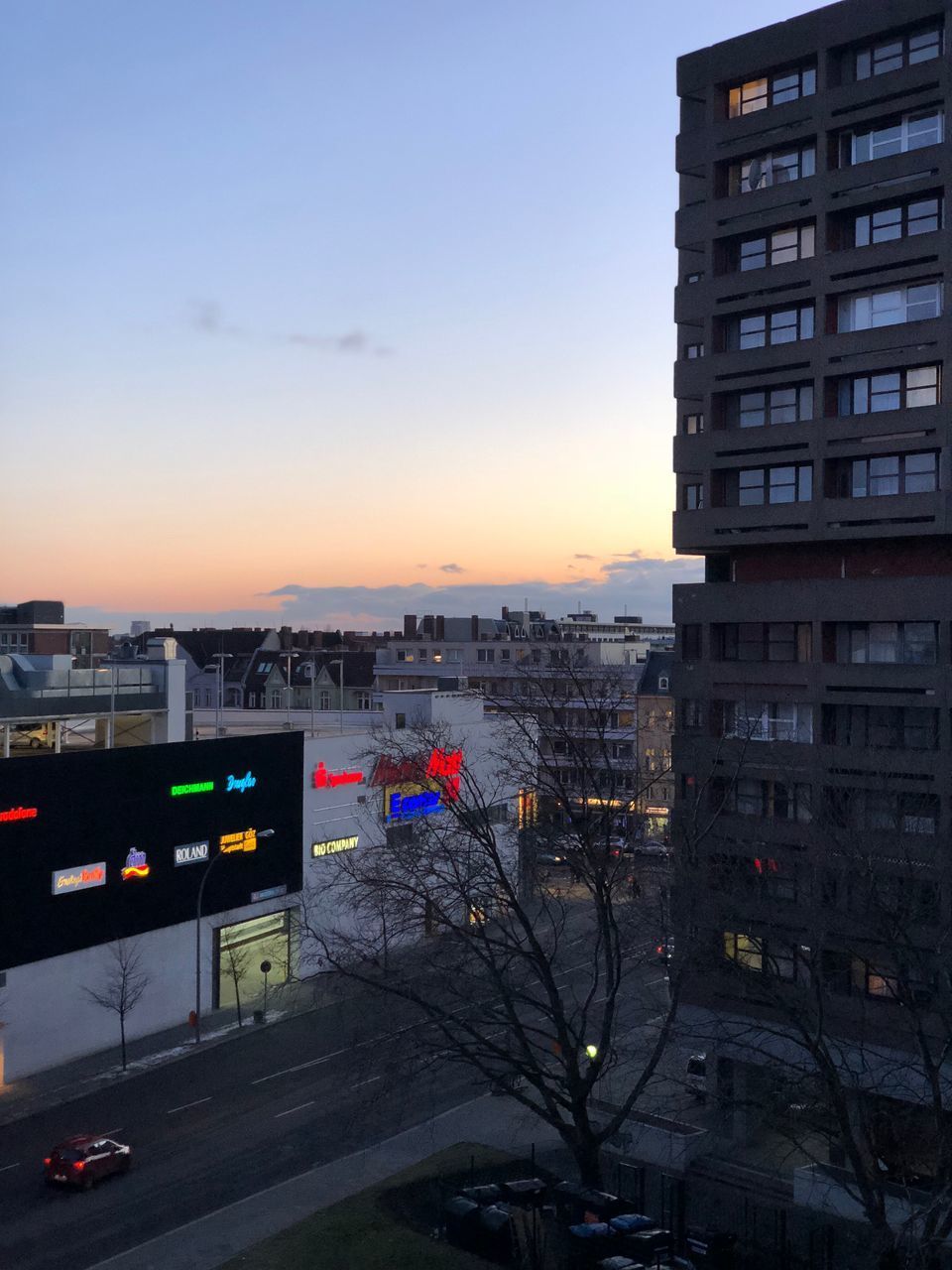 HIGH ANGLE VIEW OF ILLUMINATED CITY BUILDINGS AT SUNSET