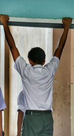 Rear view of boy hanging in corridor