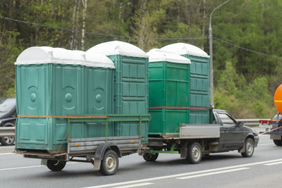 The car carries dry closets on a trailer. dry closets are transported for repairs. 