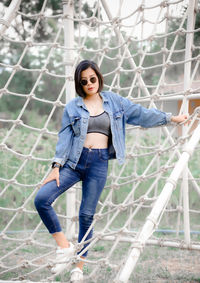 Woman standing by rope at park