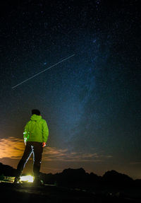 Rear view of man standing against star field at night