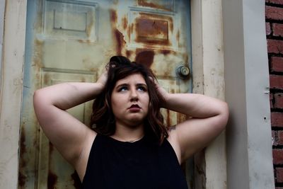 Low angle view of young woman with hand in hair