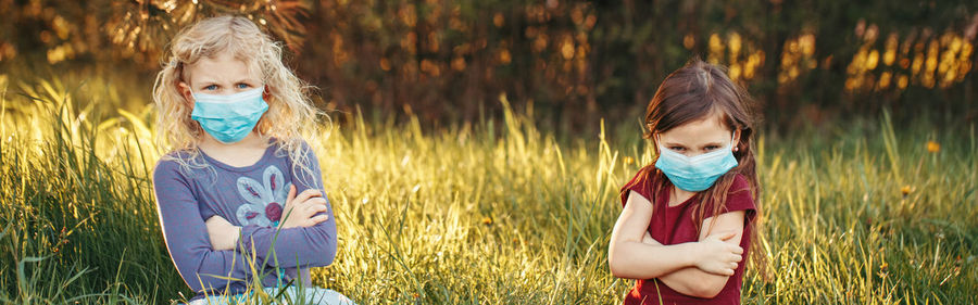 Cute girl standing by plants on field