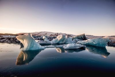 Scenic view of lake against clear sky during winter