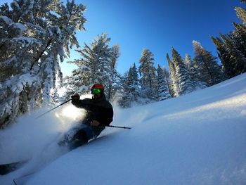 Low angle view of man skiing on snow covered mountain