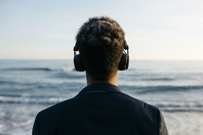 Afro man with headphones at beach