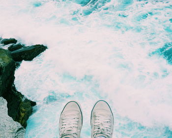 Low section of person standing in water
