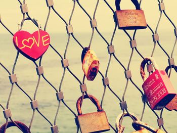 Close-up of padlocks hanging on fence