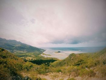 Scenic view of sea and mountains against sky