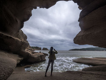 Rear view of woman standing on rock