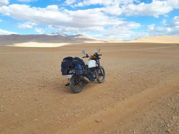 Motorcycle on arid landscape against sky