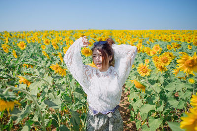 View of woman with yellow flowers in field