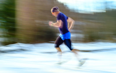 Side view of man running on road