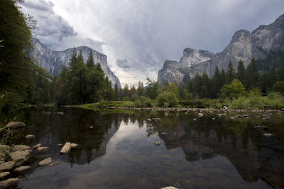 Lake surrounded by trees and mountains in forest