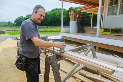 Carpenter working on wood at outdoor workshop