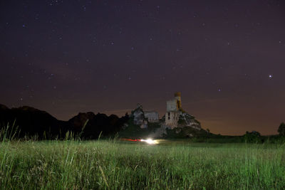 Scenic view of illuminated field against sky at night