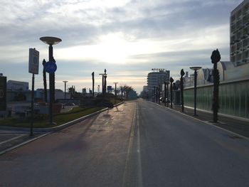 Empty road against cloudy sky