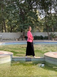 Woman standing by tree against plants