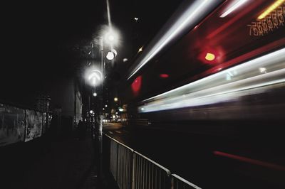 Blurred motion of illuminated railroad tracks in city at night