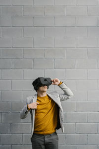 Full length of young man standing against wall