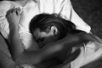 Young man sleeping on bed at home